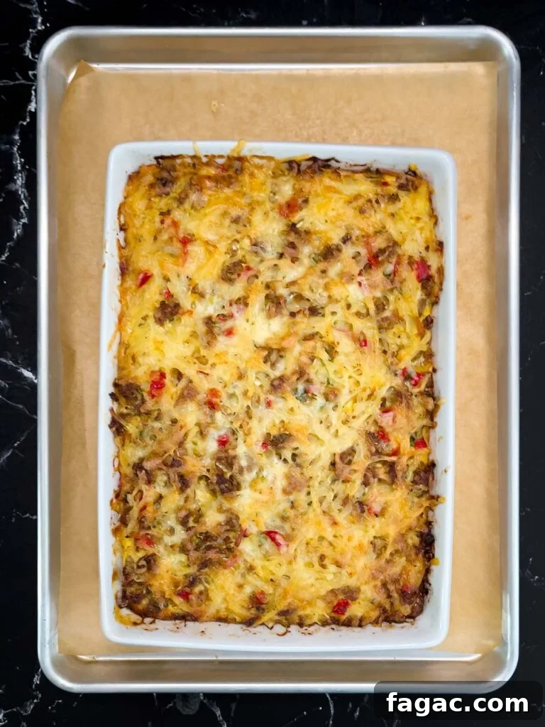 Sausage and Hashbrown Breakfast Casserole for 12 Guests 15 Golden brown baked sausage hashbrown breakfast casserole in 9x13 dish on baking sheet
