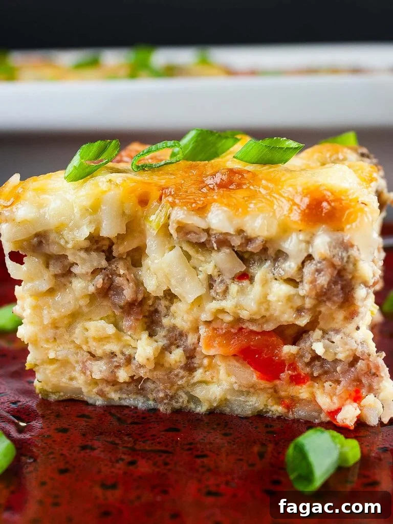 Sausage and Hashbrown Breakfast Casserole for 12 Guests 17 A serving of Sausage Hashbrown Breakfast Casserole on a red plate, garnished with chopped green onions.