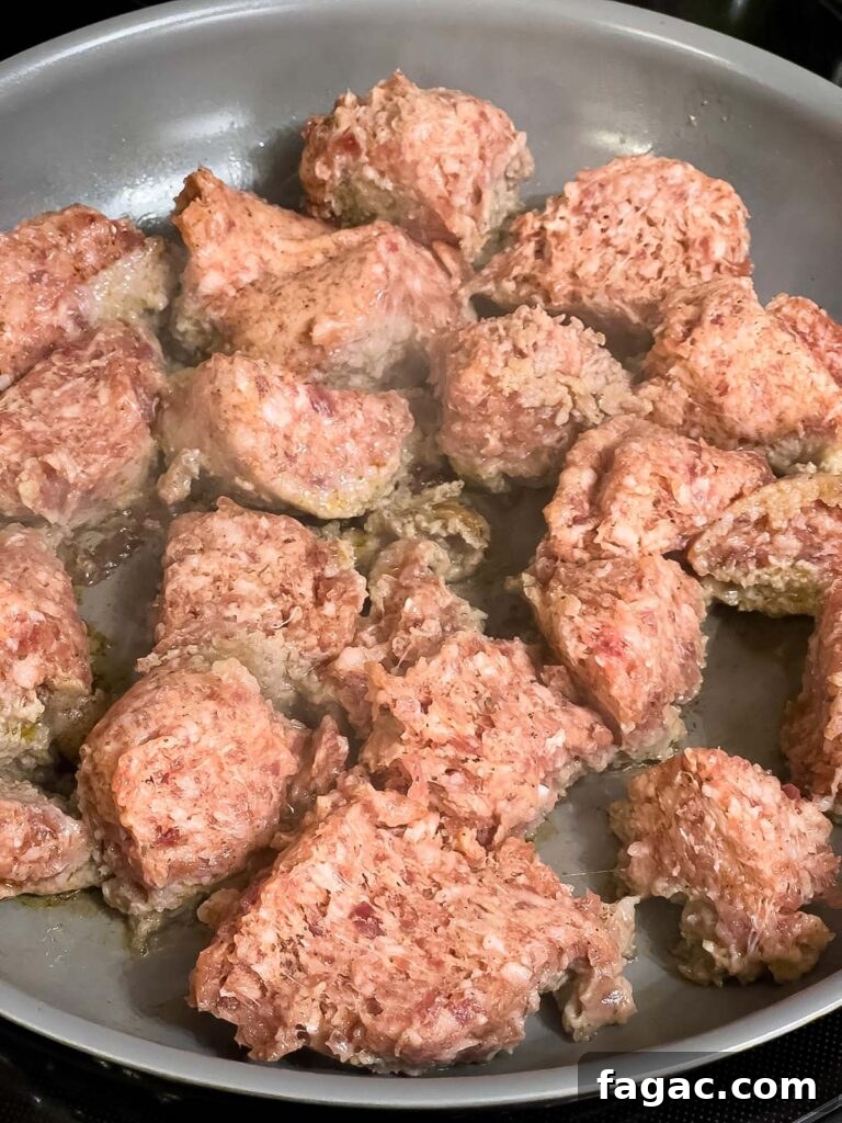 Sausage and Hashbrown Breakfast Casserole for 12 Guests 4 Breakfast sausage browning in large chunks in a skillet.