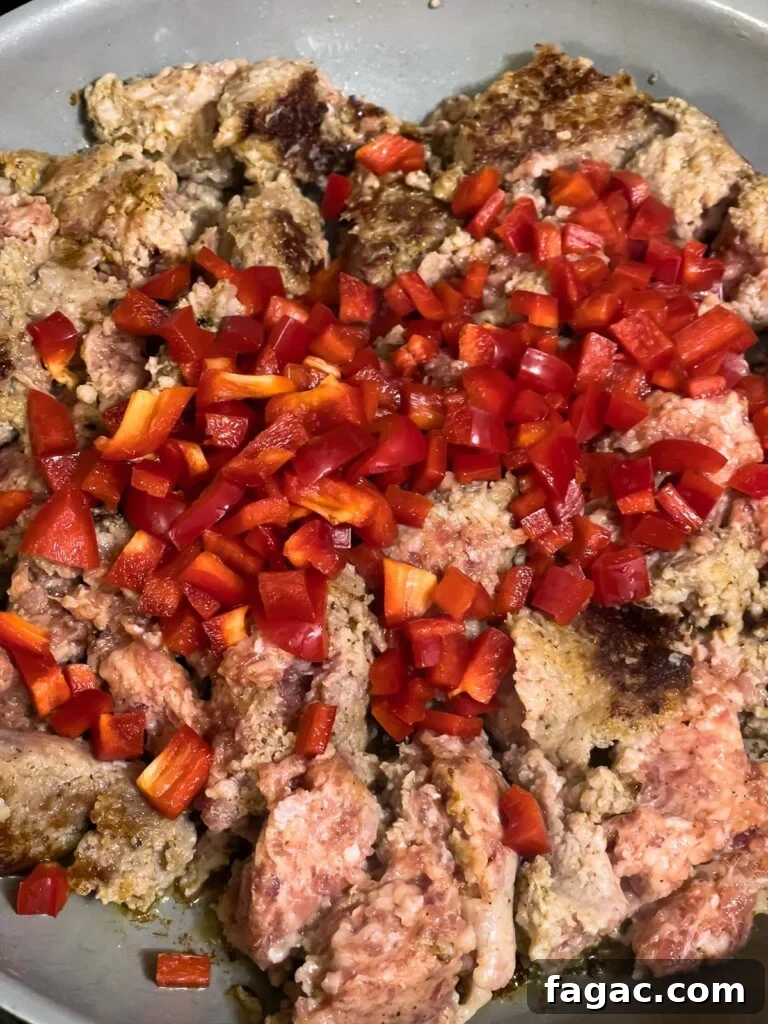 Sausage and Hashbrown Breakfast Casserole for 12 Guests 6 Diced red bell peppers added to browned sausage in skillet.
