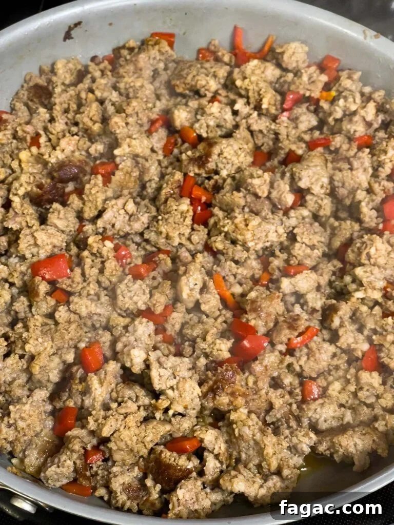 Sausage and Hashbrown Breakfast Casserole for 12 Guests 7 Cooked sausage and softened red bell peppers in skillet.