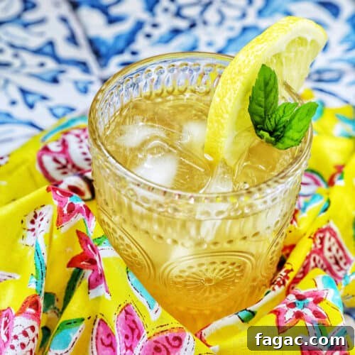 glass of bourbon lemonade on a bright colorful napkin with title text overlay.