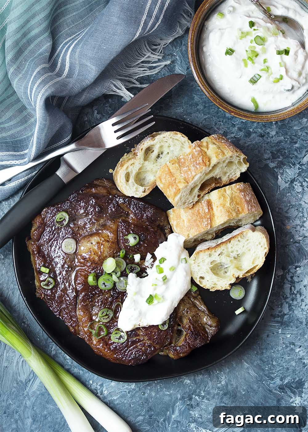 Top view of a plate with a pan seared ribeye steak topped with horseradish sauce.