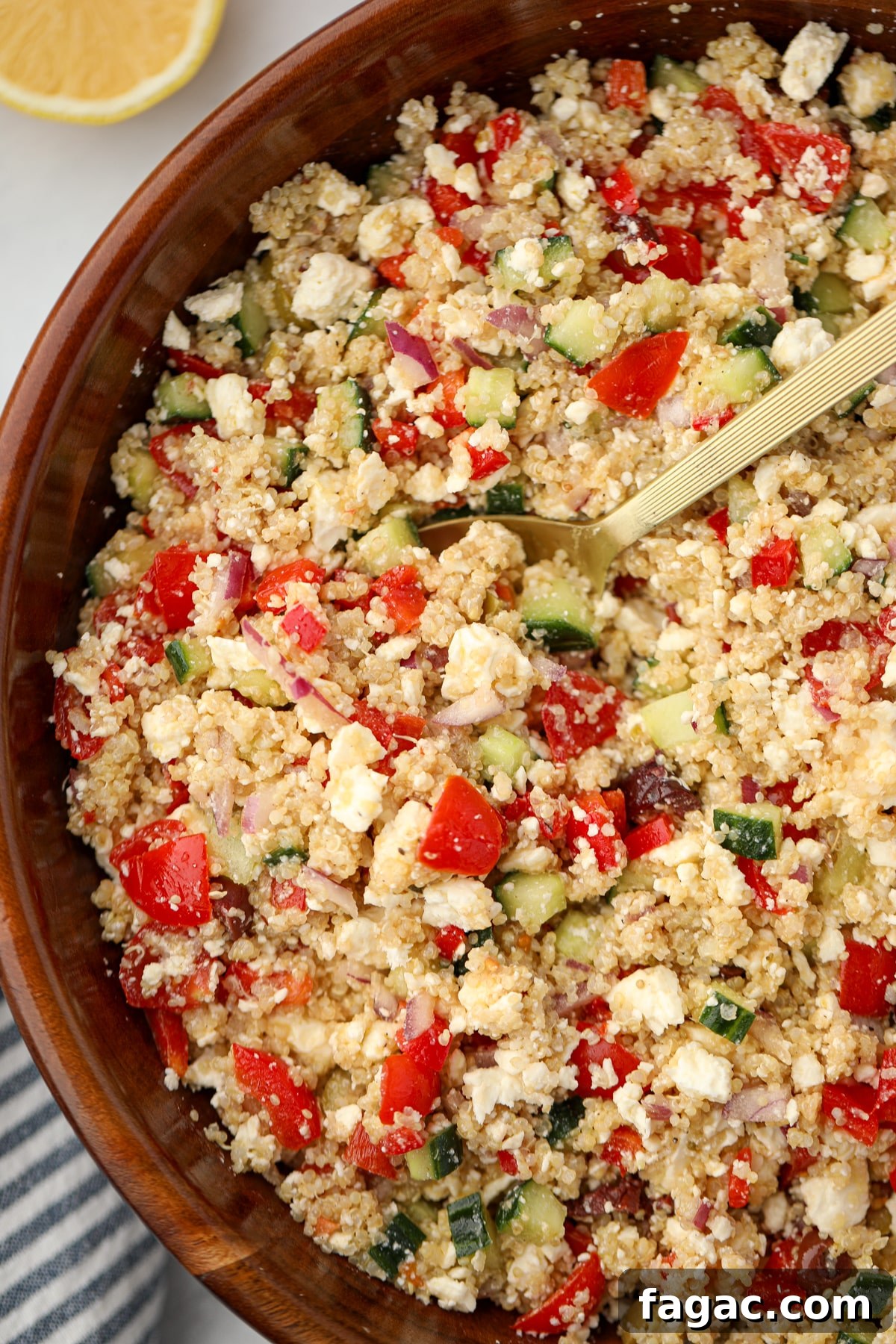Scooping a portion of quinoa salad from a large salad bowl.