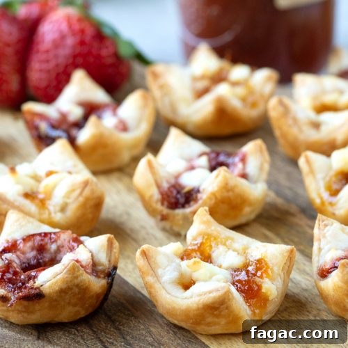 puff pastry appetizers with goat cheese and jam on a wooden board