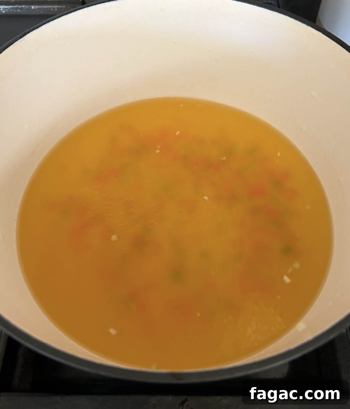 Chicken stock and vegetables in dutch oven.