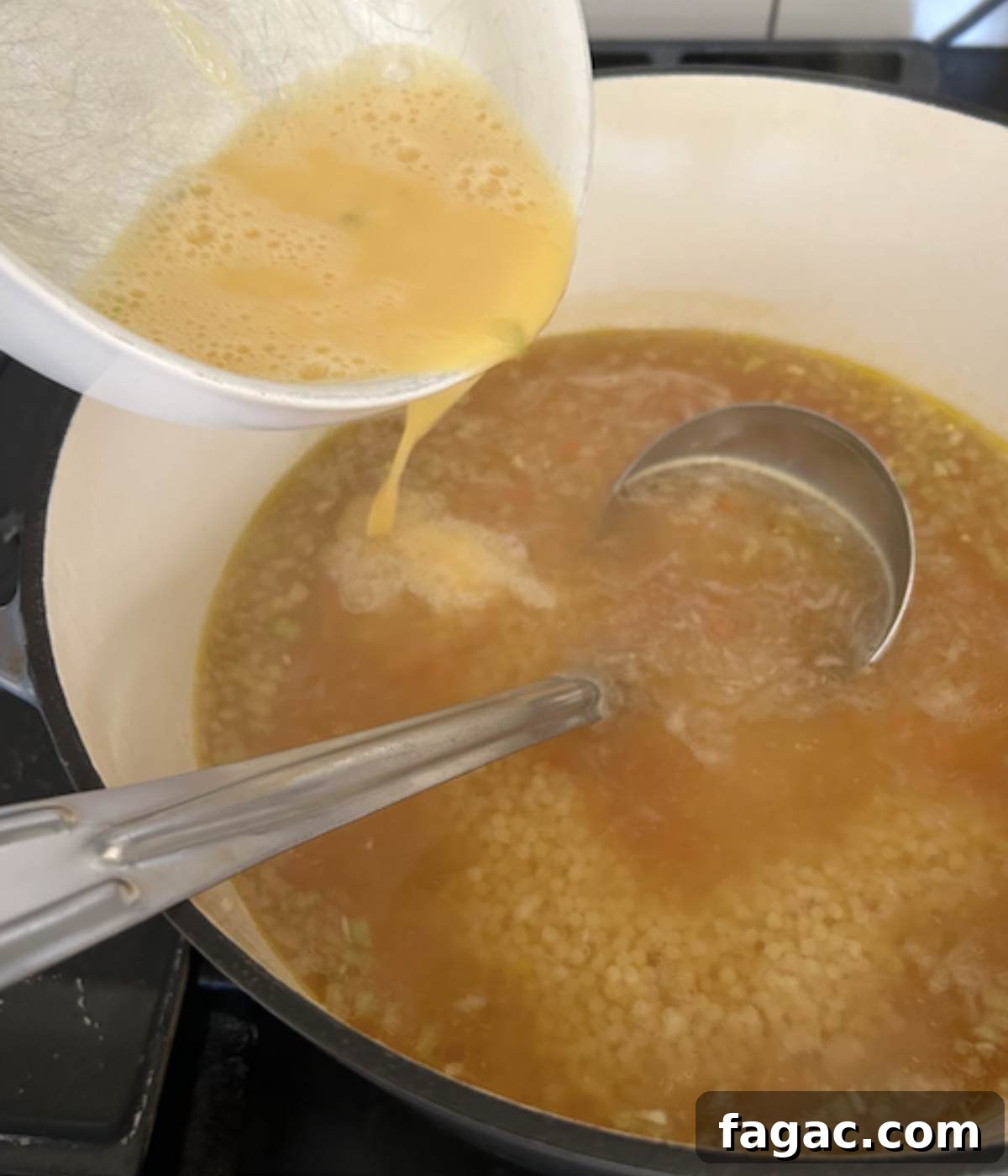 Pouring egg into pastina soup.