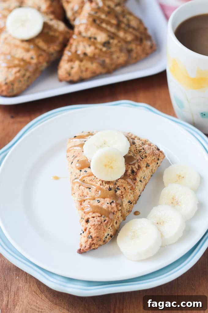 Banana Black Sesame Vegan Scones - easy dairy free scones with a surprisingly delightful flavor combo. Just sweet enough with no refined sugar. They have the perfect balance of sweet and nutty. You've gotta try these amazing scones - breakfast, brunch, tea time, even dessert! Pastry topped with banana slices with more banana slices lying on the plate.