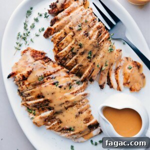 Slow-Cooker Turkey Breast Recipe for Juicy, Tender Meat 2 Sliced turkey breast cooked in a crockpot, served on a plate topped with gravy and garnished with fresh herbs.