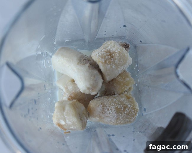 Peanut Butter Chocolate Chip Nice Cream Recipe for Creamy Frozen Dessert 5 Frozen bananas and milk in a blender.
