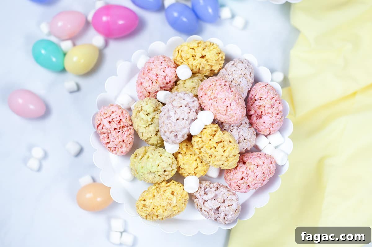 Easter Rice Krispie Treats: Festive Bunny and Egg Recipes 6 top view of easter rice krispie treats on white serving platter sprinkled with white mini marshmallows and plastic Easter eggs in the background