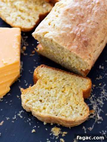 Loaf of Quick Peppery Cheese Bread sliced on a cutting board