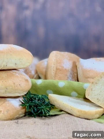 stack of herb sourdough ciabatta rolls with one slice