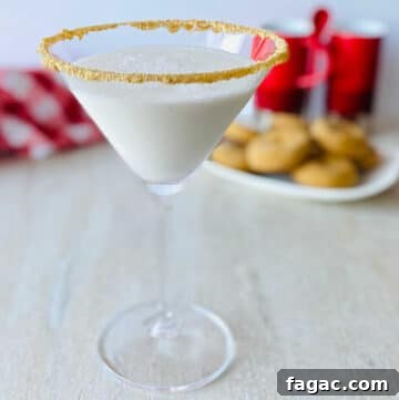 Gingerbread Martini Christmas Cocktail in martini glass with gingerbread cookies in the background