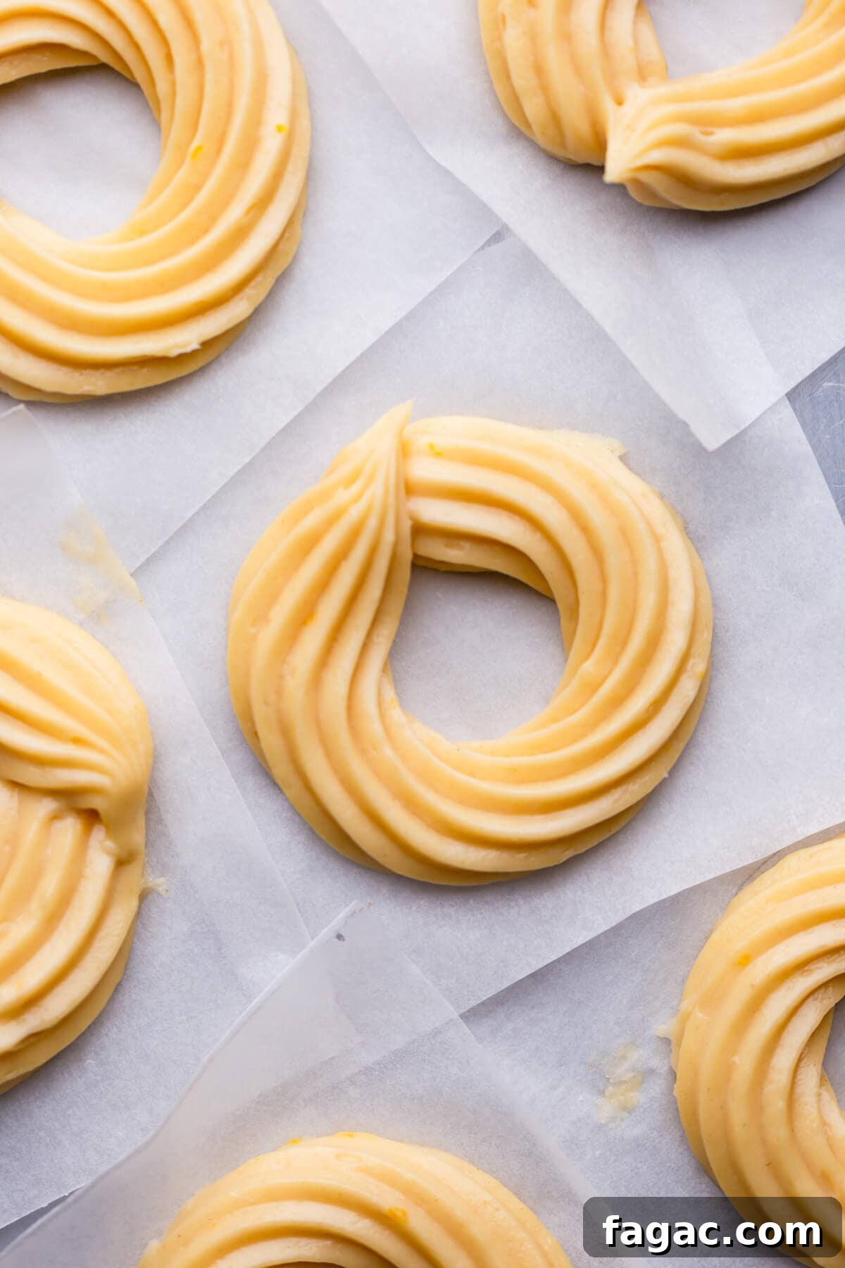 Classic French Cruller Donuts: Light, Crispy Pastry Recipe 4 overhead view of raw french cruller doughnuts on parchment paper