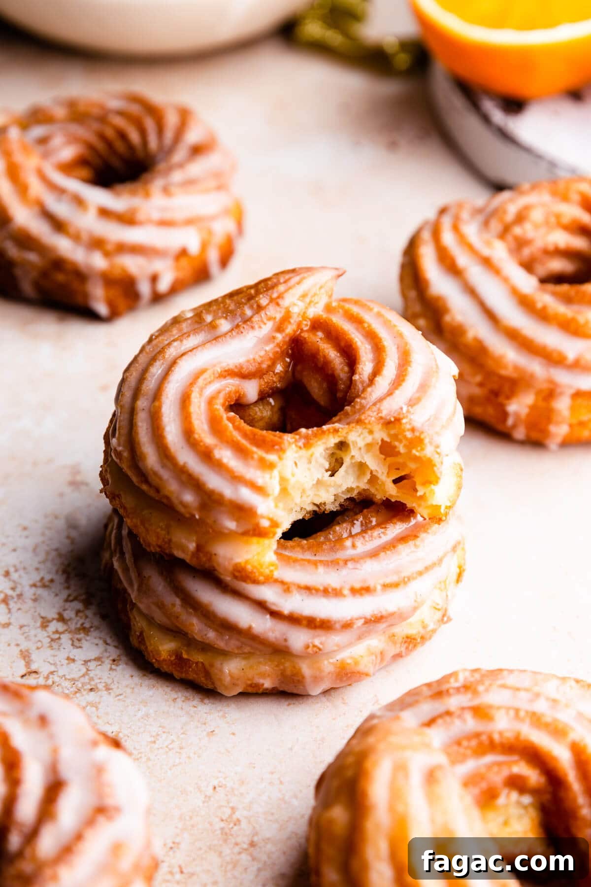 Classic French Cruller Donuts: Light, Crispy Pastry Recipe 8 a side close up at a stack of two crullers with the top one missing a bite