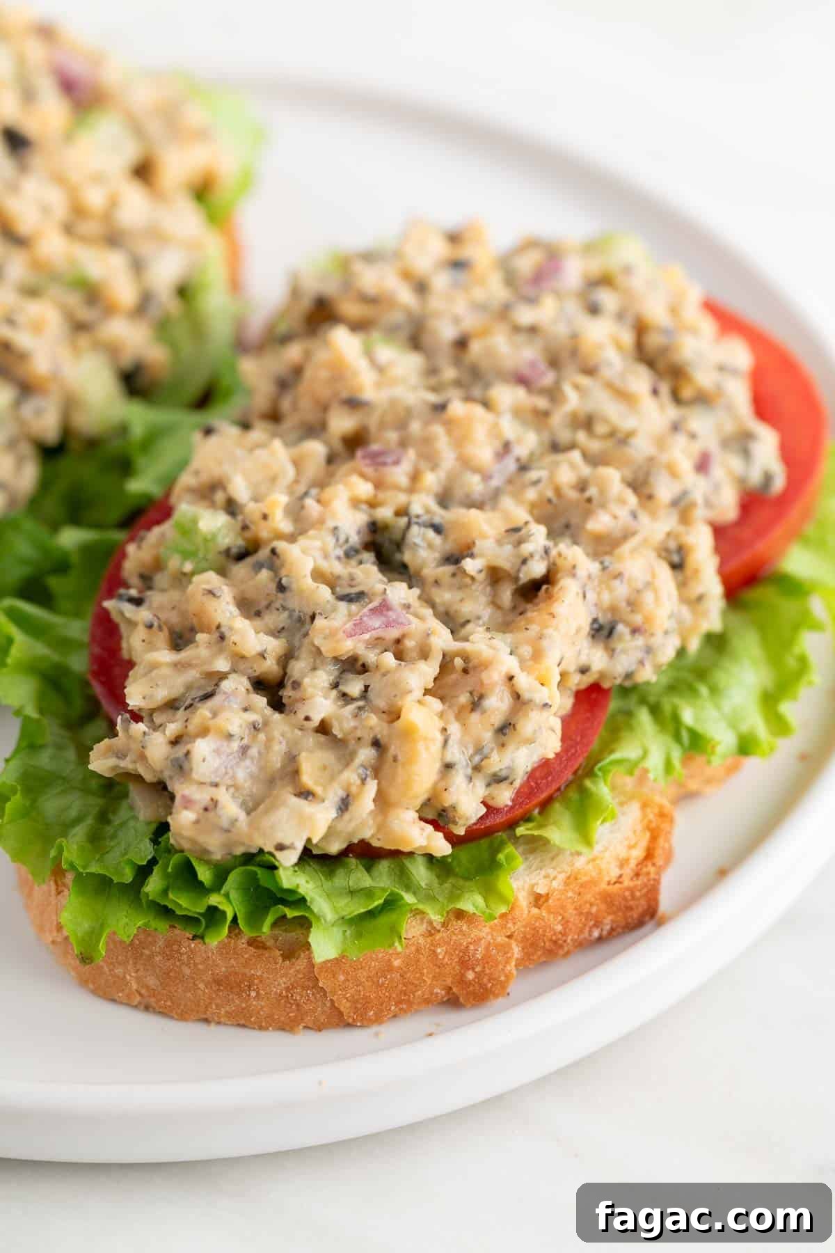 Vegan Tuna Recipe: Plant-Based Tuna Alternative Guide 2 Vegan tuna on a slice of bread with lettuce and tomato slices.