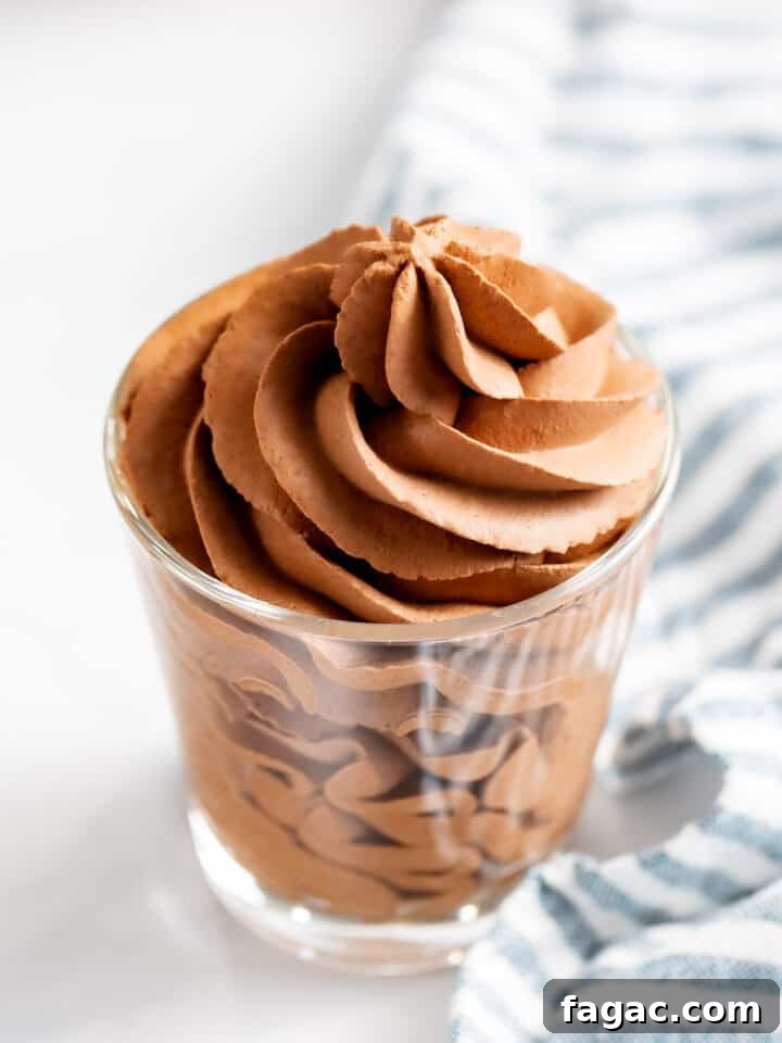 Chocolate whipped cream piped into a glass cup.