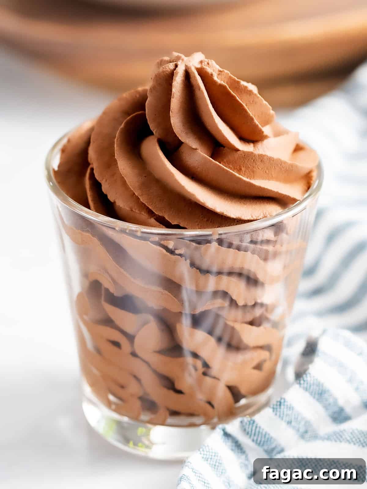 Chocolate whipped cream piped into a glass cup.