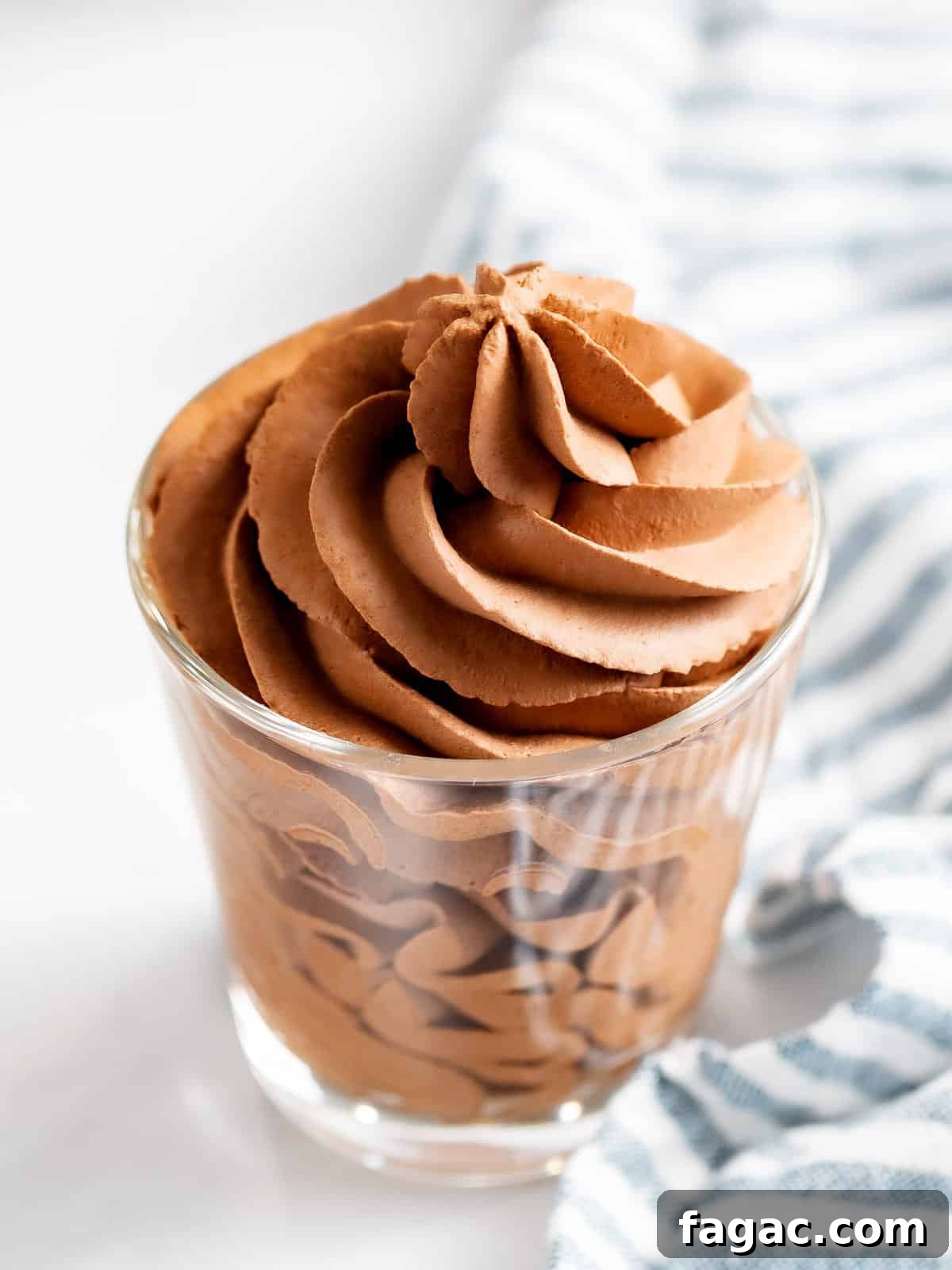 Chocolate whipped cream piped into a glass cup.