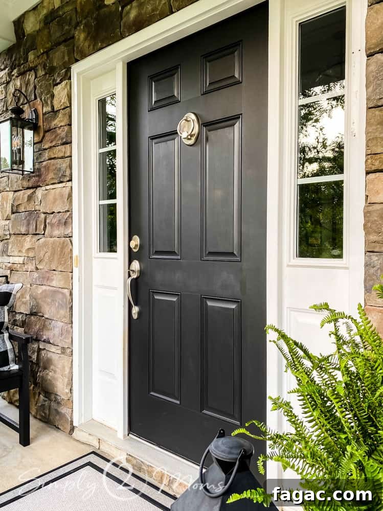 after photo of small front porch with black front door and silver hardware decorated for summer