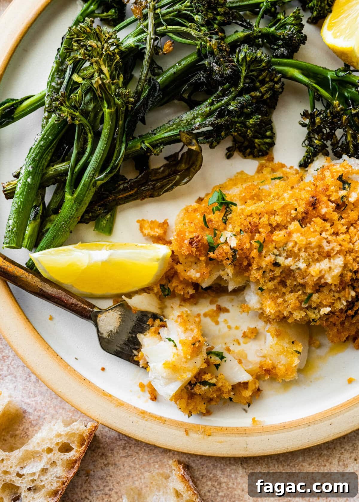 Crispy Panko-Baked Cod with Lemon Garlic Sauce 11 crispy baked cod with panko on a plate with broccolini. Bite taken out of fish.
