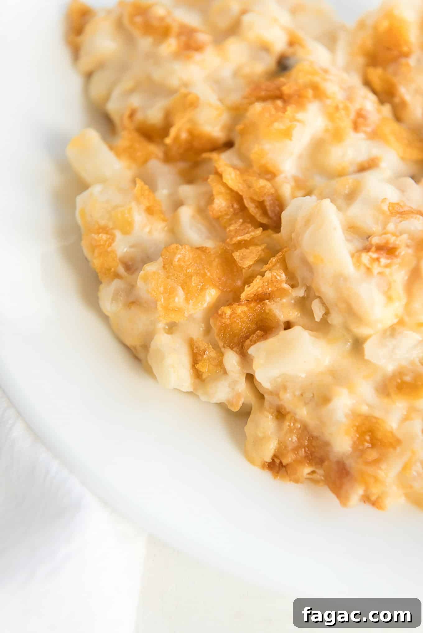 Cheesy hash brown potatoes on white plate.