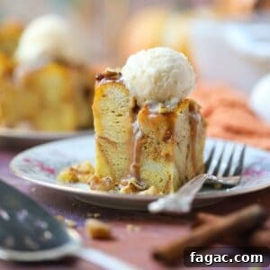 Salted Caramel Pumpkin Bread Pudding Recipe 13 A serving of pumpkin bread pudding with salted caramel sauce and vanilla ice cream on a white dessert plate with a silver fork.