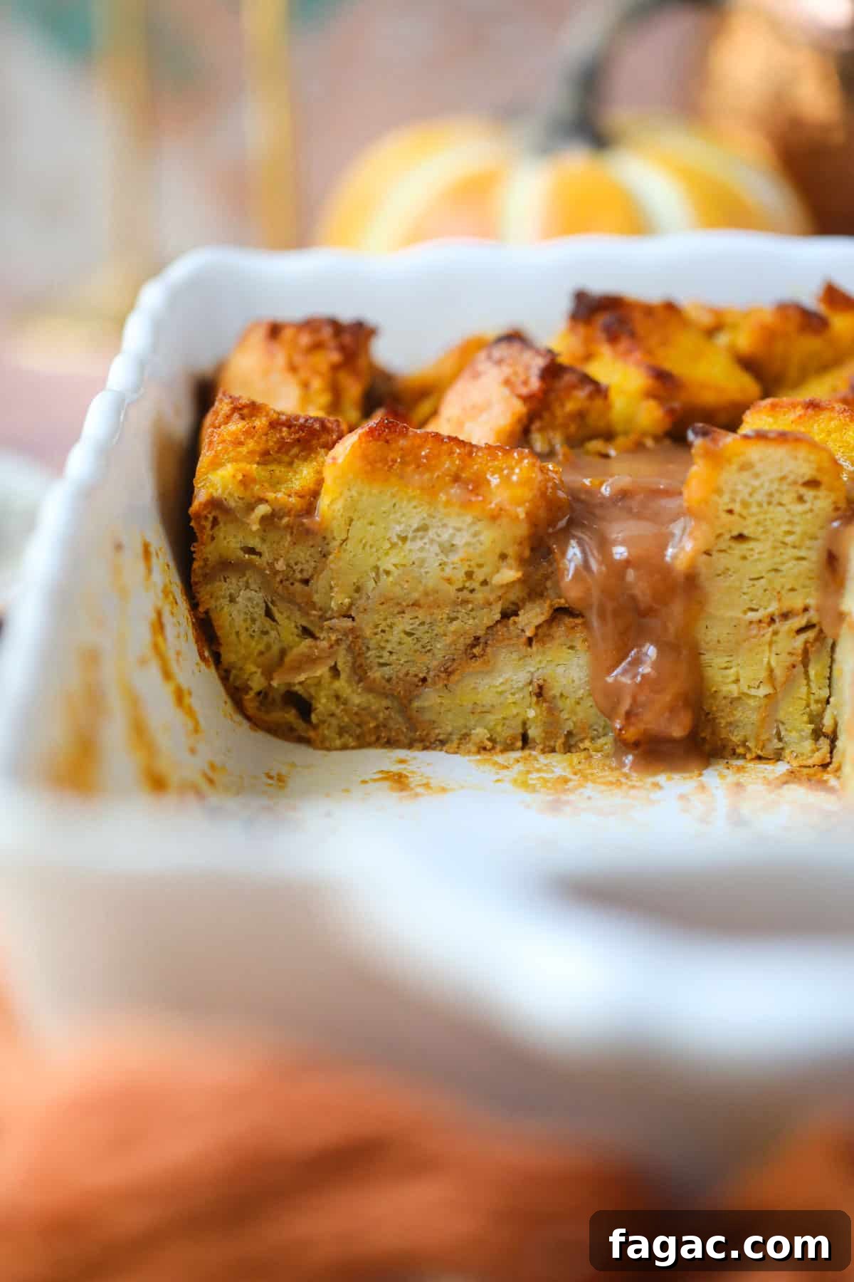 Salted Caramel Pumpkin Bread Pudding Recipe 7 Pumpkin bread pudding with salted caramel sauce that has been sliced in a white baking dish.