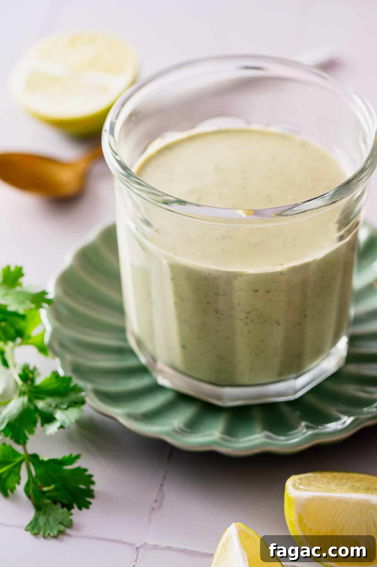 Vegan Cilantro Lime Dressing — Dairy-Free Paleo Recipe 7 A glass jar filled with a creamy salad dressing.