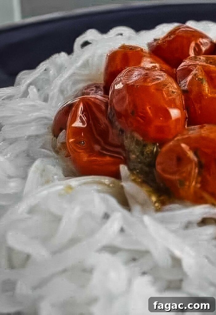 a closeup of a plate of miracle noodles topped with a thick cherry tomato sauce