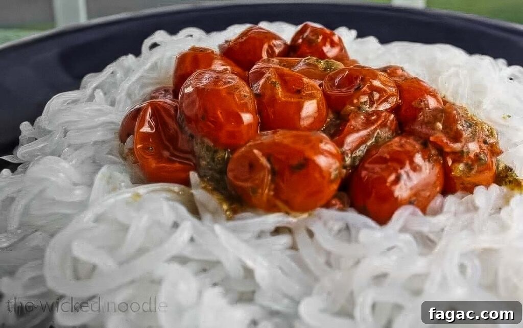 a plate of miracle noodles topped with a thick cherry tomato sauce