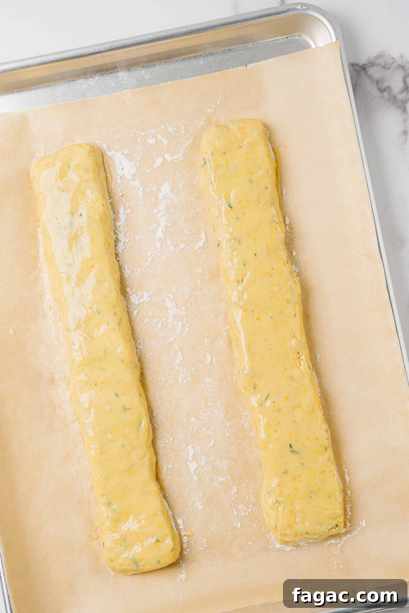 Buttery Orange Biscotti: Classic and Almond Variations 4 Logs of orange biscotti dough on a parchment-lined baking sheet ready for the first baking in the oven.