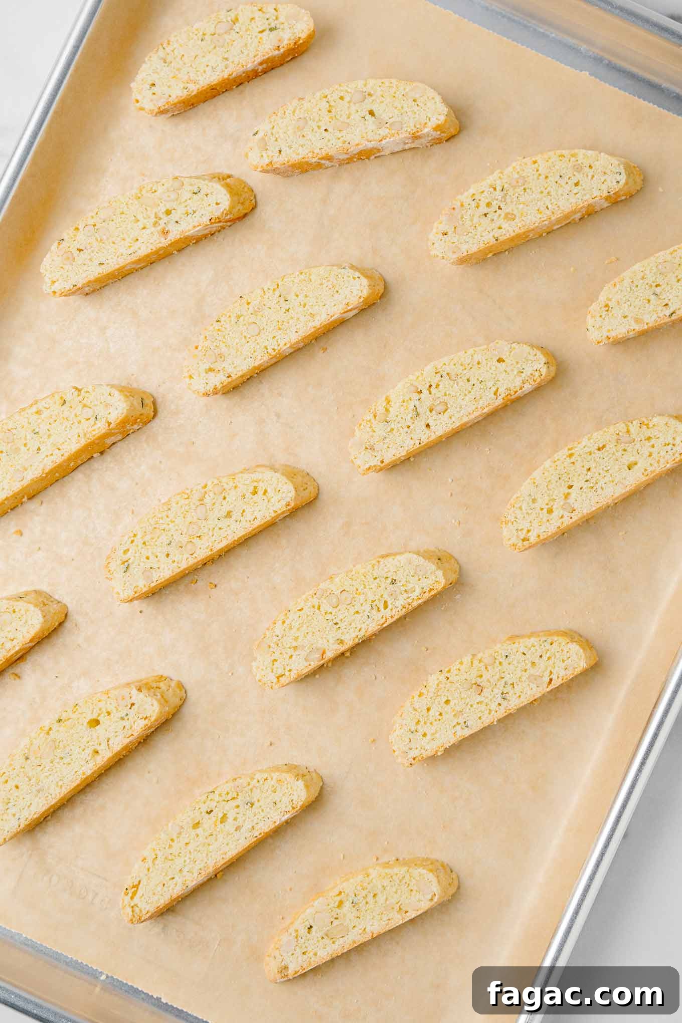 Buttery Orange Biscotti: Classic and Almond Variations 6 Golden brown American style biscotti (made with butter) on a parchment lined baking sheet after their second baking.