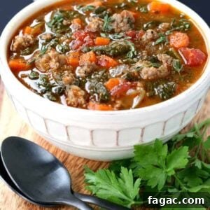 Low Carb Sausage Vegetable Soup in a bowl on a board with spoons