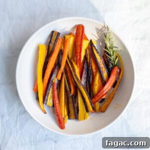 Rosemary Roasted Carrots with 4 Simple Ingredients 7 rainbow rosemary roasted carrots in a white serving dish.