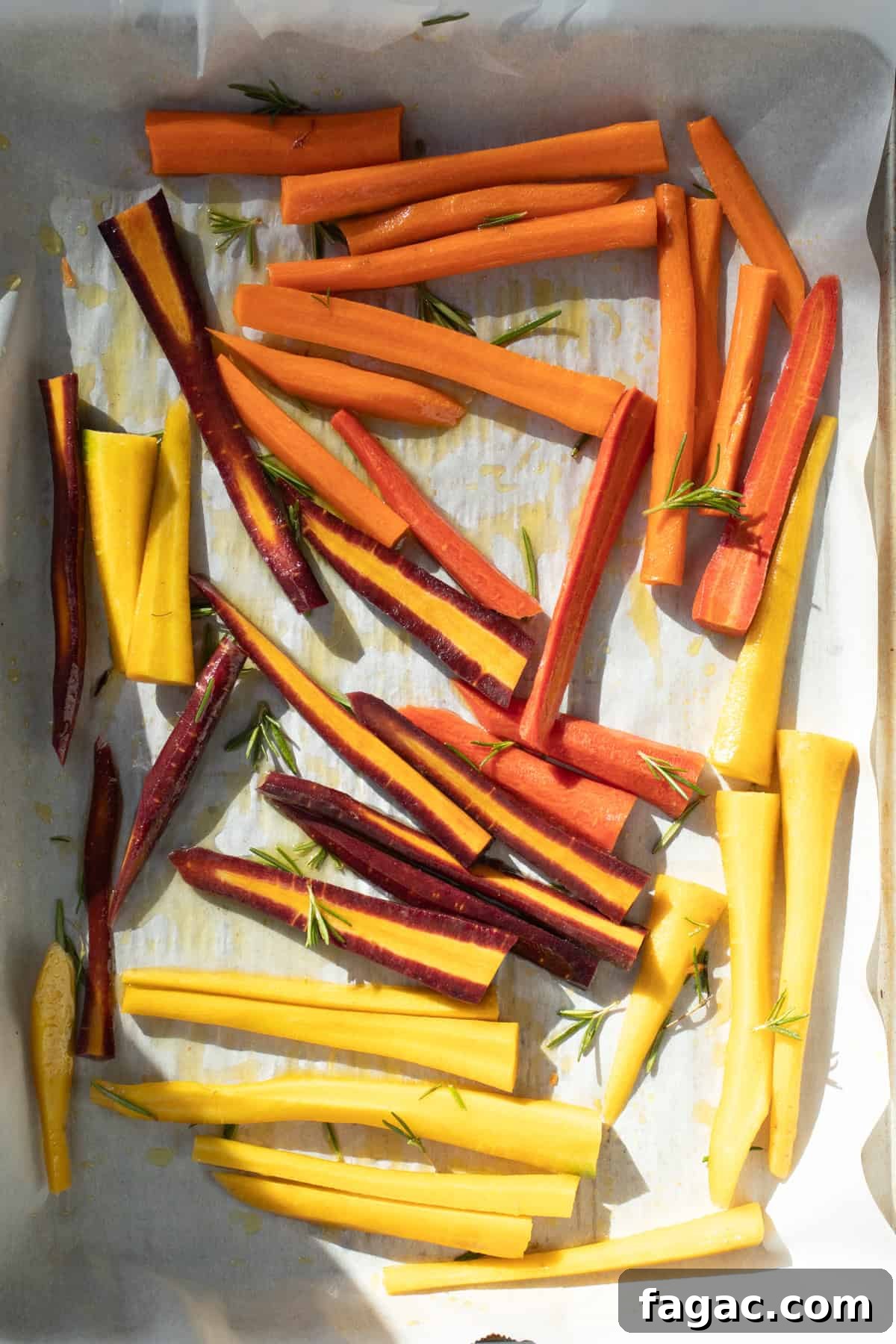 Rosemary Roasted Carrots with 4 Simple Ingredients 5 cut carrots on a baking sheet drizzled with olive oil and rosemary.