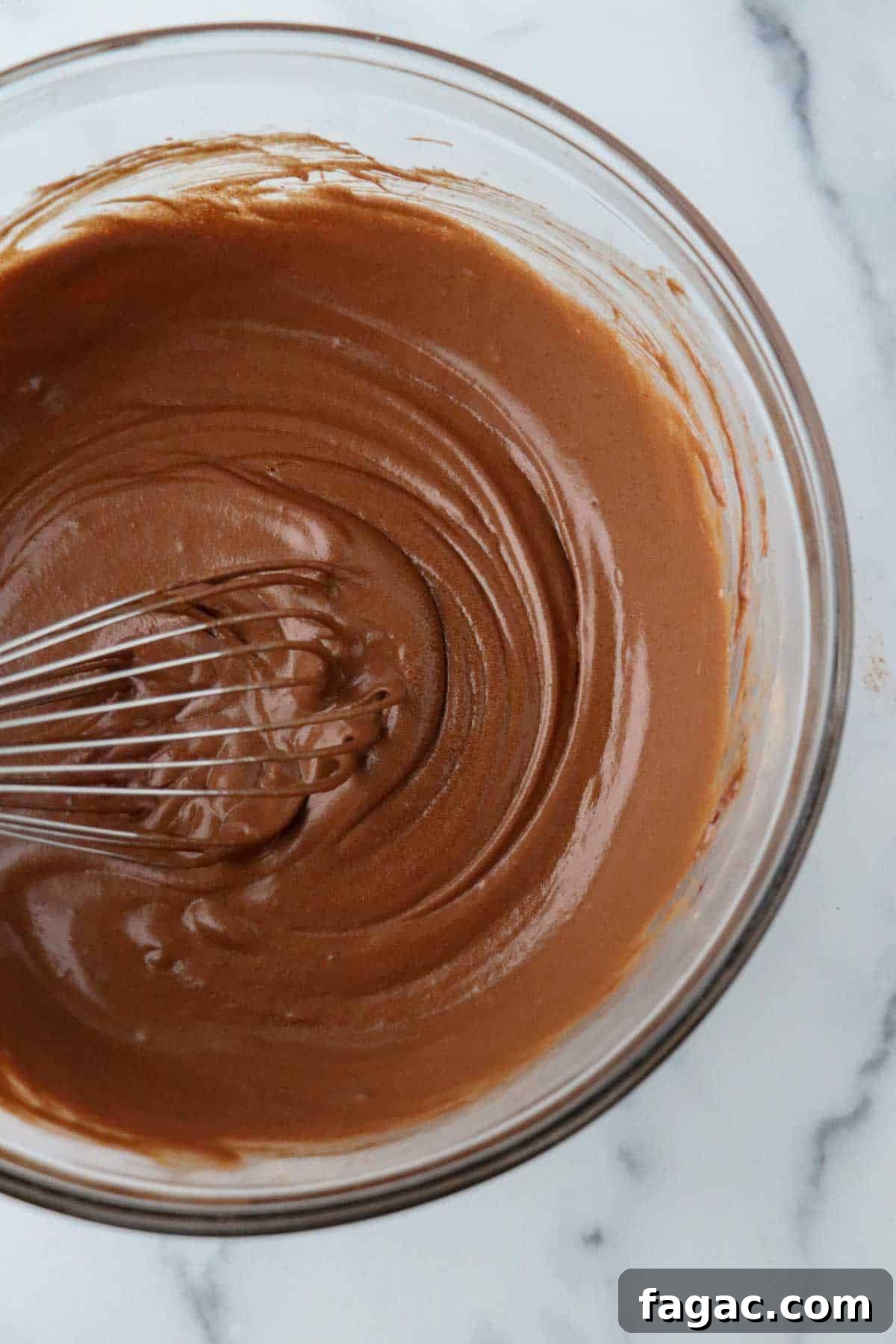 Authentic Swedish Kladdkaka: Gooey Sticky Chocolate Cake Recipe 6 Smooth chocolate cake batter in a glass bowl with a whisk.