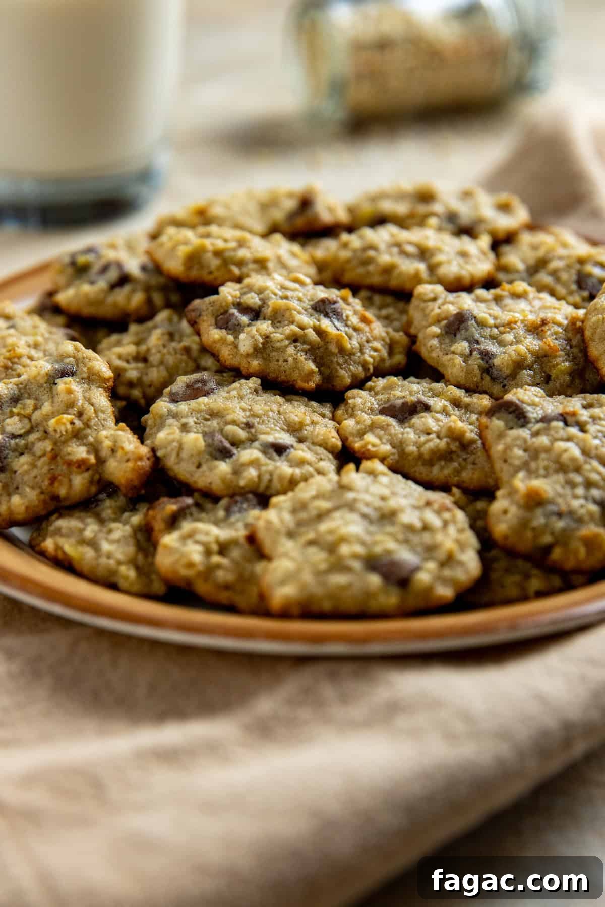 Chocolate Chip Banana Oat Oatmeal Cookies Recipe 2 Baked cookies piled on a brown serving platter.