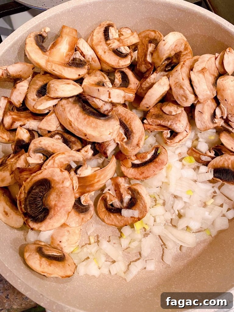Quick Ground Beef Stroganoff Recipe for Weeknights 3 Mushrooms and onions sauting in a large skillet.