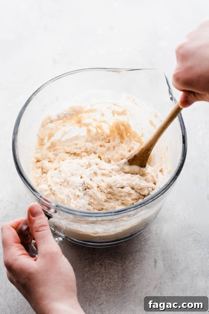 Classic Beer Bread with Salted Honey Butter Recipe 4 A hand stirring the beer bread batter in a mixing bowl