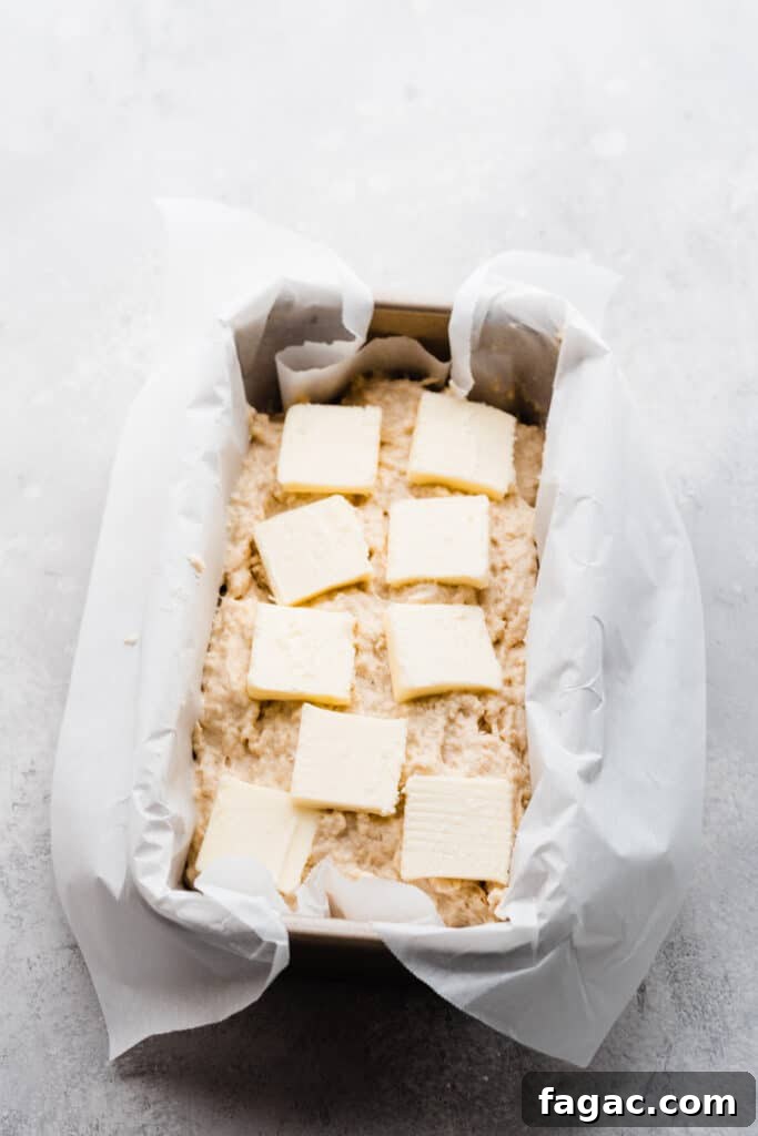 Classic Beer Bread with Salted Honey Butter Recipe 6 Beer bread batter in a loaf pan topped with slices of butter