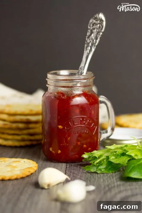 Homemade Sweet Chili Jam Recipe for Bold Flavor 8 sweet chilli jam in a kilner jar with crackers, lettuce and garlic cloves