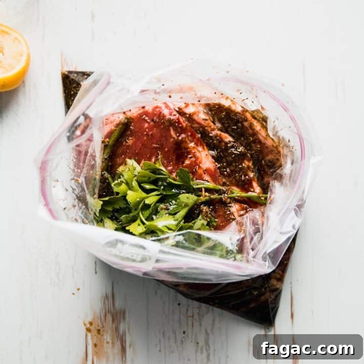 Steaks in zip top bag with marinade and parsley on top.