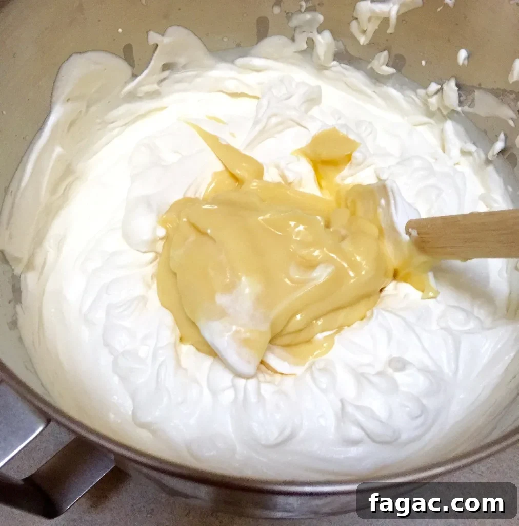 Éclair Cake, folding pudding mixture into whipped cream.