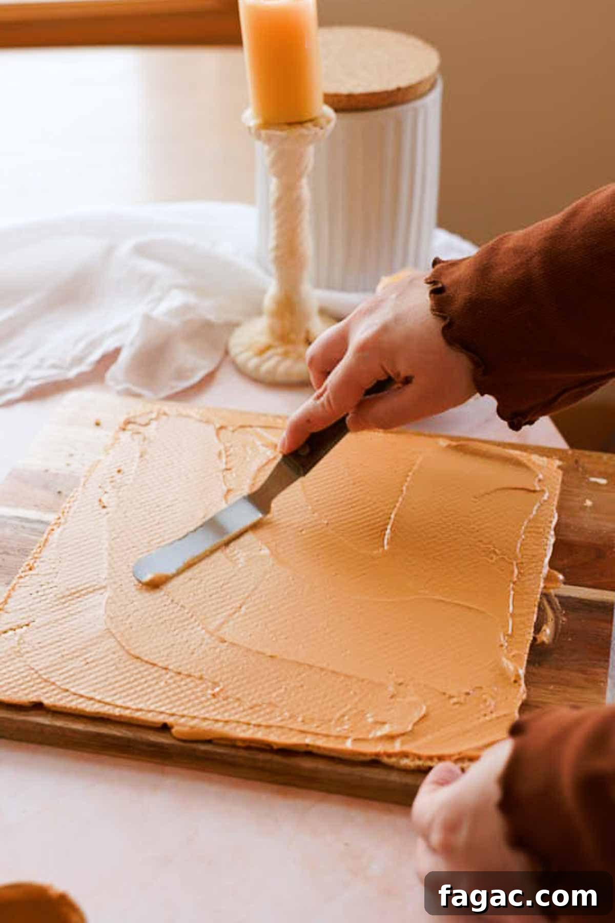 spreading dulce de leche filling between wafer layers
