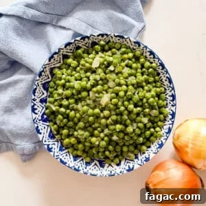 Creamy Garlic Green Peas with Parmesan 14 An overhead image of a bowl of green peas and onions.
