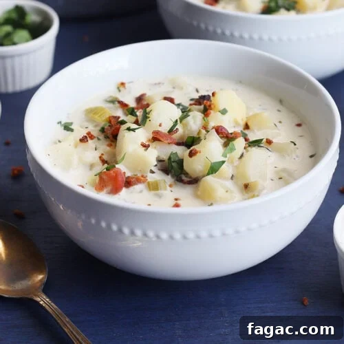 Old-fashioned potato soup in a white bowl garnished with chopped bacon bits and parsley.