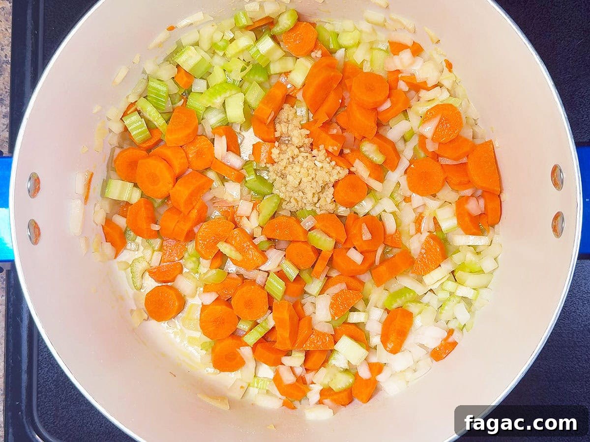 Creamy Potato and Sweet Corn Chowder Recipe 4 Sauteing diced carrots, celery, onions, and minced garlic in a large stock pot.