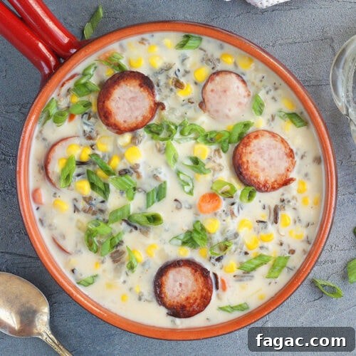 A serving of smoked sausage corn chowder garnished with green onions.